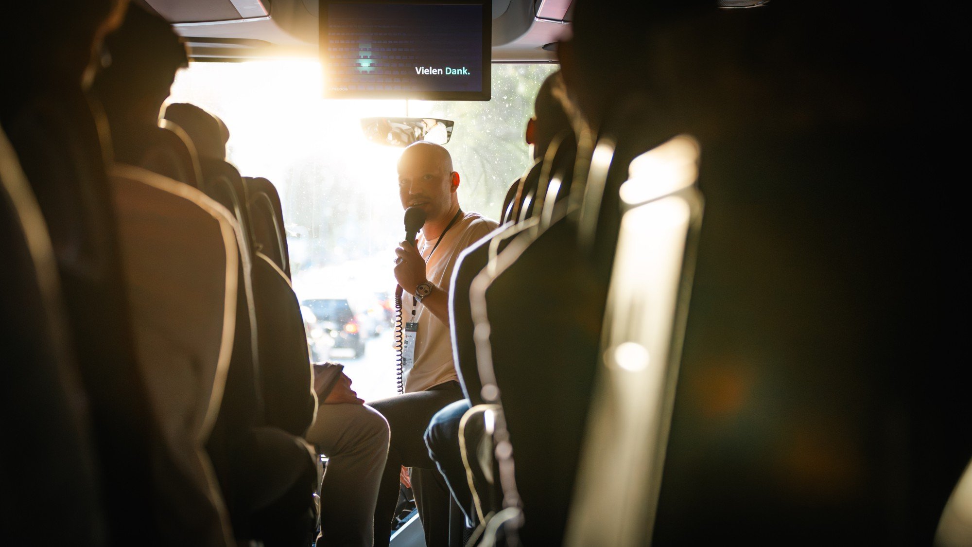 Vortrag am Busmikrofon während der Fahrt, im Gegenlicht
